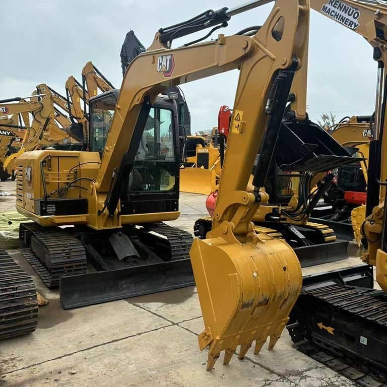 Large yellow used excavator secured on a Maersk shipping chassis for international export at a busy port facility.